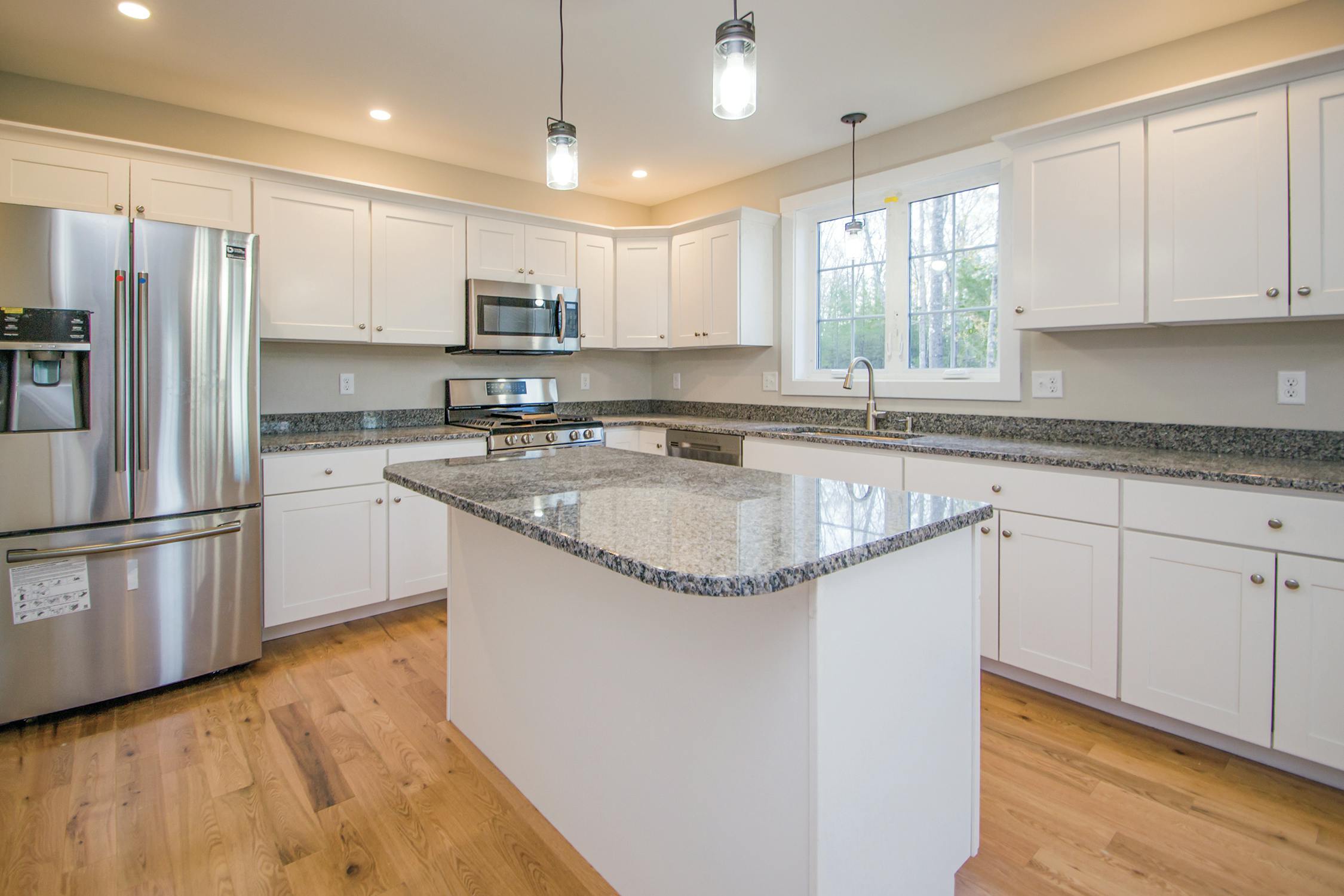 white kitchen with granite counters in new home